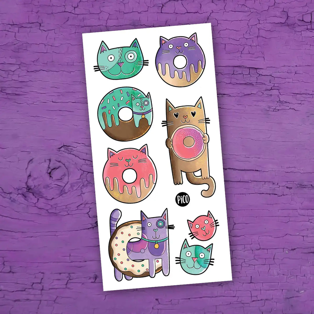 Tatouages temporaires chats-beignes, illustrations colorées de beignes en chat pour enfants.
Cat donut temporary tattoos, colorful cat-shaped donut illustrations for kids.