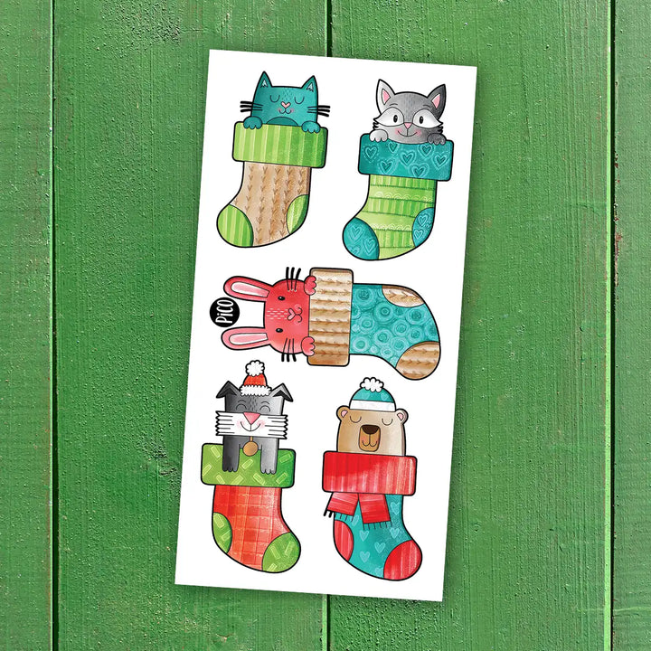 Tatouages temporaires bas de Noël avec animaux, motifs rouges et verts, style cartoon, pour enfants.
Christmas stocking temporary tattoos with animals, red and green cartoon designs for kids.